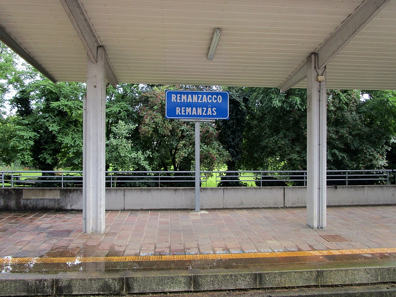 Zweisprachiges Bahnhofsschild in Remanzacco (furlanisch Remanzâs)