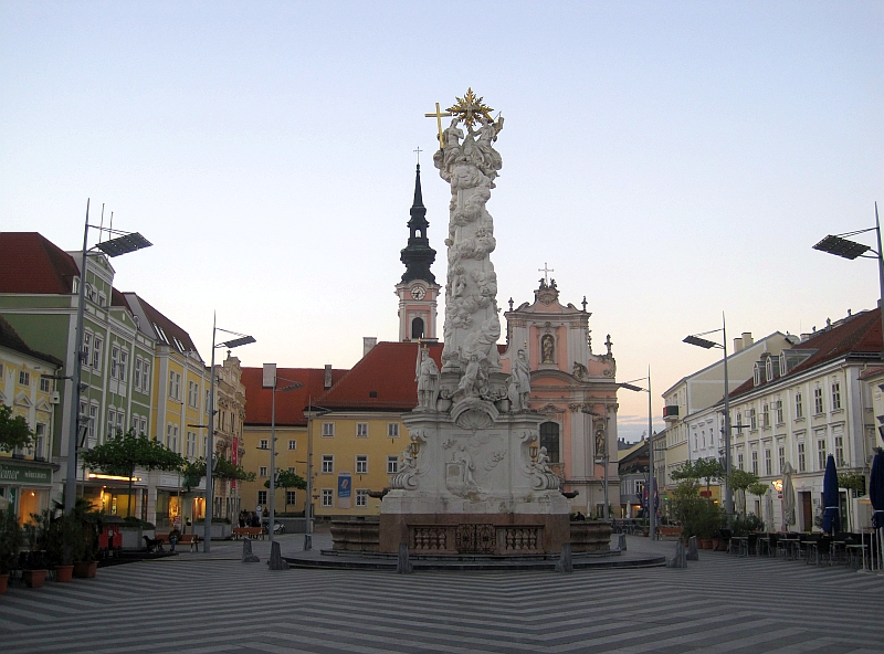 Dreifaltigkeitssäule auf dem Rathausplatz, im Hintergrund die Franziskanerkirche