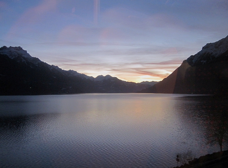 Blick vom Zugfenster auf den Sonnenuntergang über dem Brienzersee
