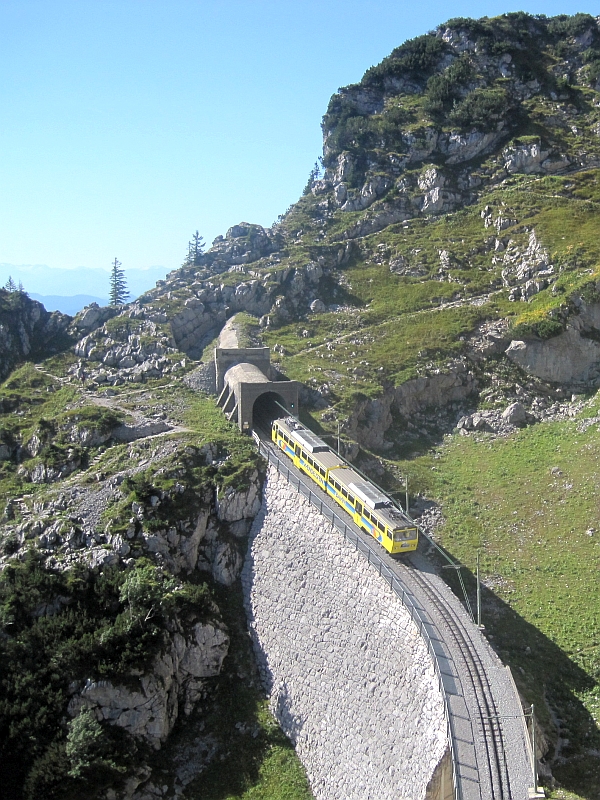 Ein Zug der Wendelsteinbahn verlässt den Tunnel am Bergbahnhof