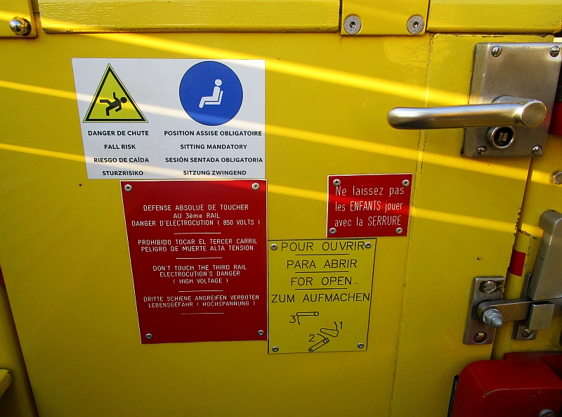 Mehrsprachige Hinweisschilder an den Türen des Sommerwagens des train jaune