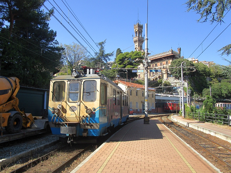 Elektrotriebwagen A11 der Ferrovia Genova-Casella, im Hintergrund der Turm des Castello Mackenzie