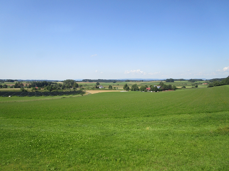 Blick aus dem Zugfenster auf Landschaft Oberschwabens, jenseits des Solarparks verläuft die Württemberg-Allgäu-Bahn