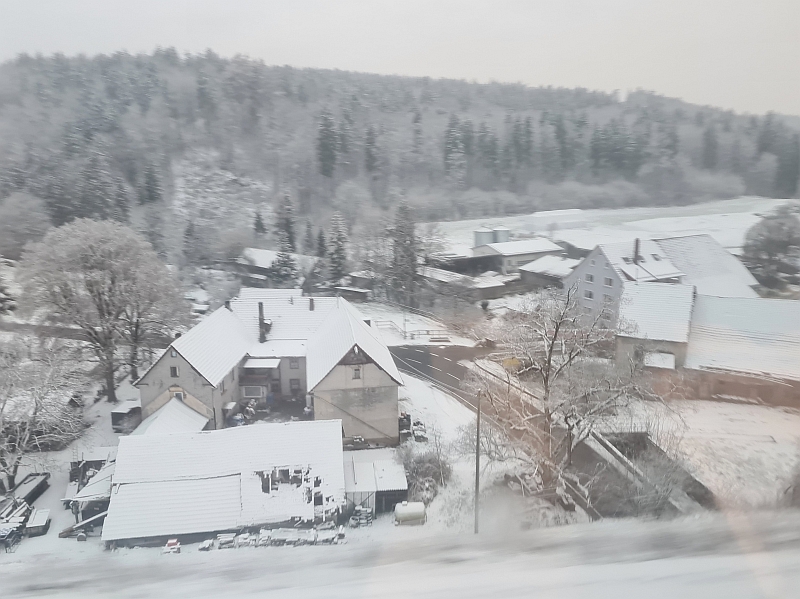Blick vom Zug auf den Weiler Talmühle bei Engen