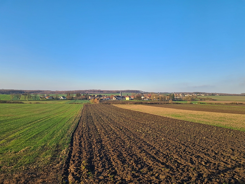 Blick vom Zug auf das Dorf Arriance